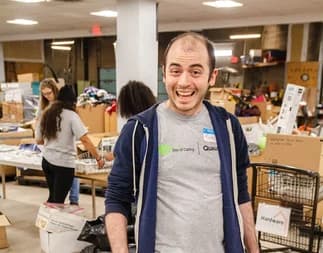 Qualitrol volunteer smiling while packing donation boxes