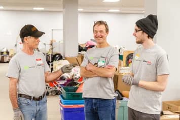 Three Qualitrol volunteers preparing donations at a community service event