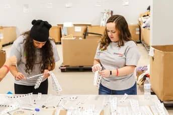 Two volunteers organizing boxes of supplies for donation